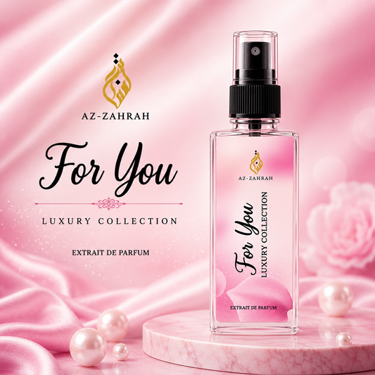 A clear rectangular perfume spray bottle labeled 'AZ-ZAHRAH For You Luxury Collection Extrait de Parfum' stands on a pink marble pedestal against a pink satin backdrop with pearls and roses. Brand text and logo appear on the bottle and in the background.