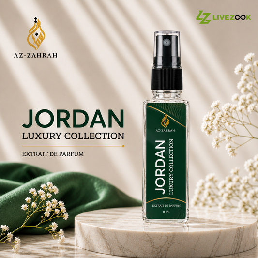 An 8 ml clear glass perfume spray bottle with a black pump and a dark green label reading 'JORDAN LUXURY COLLECTION' by AZ-ZAHRAH, displayed on a marble pedestal with green fabric and white flowers against a beige background with leaf shadows.